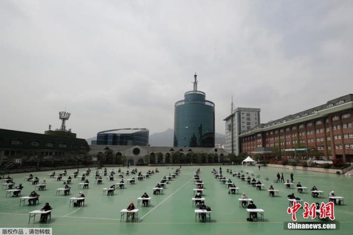 当地时间4月25日,为了防止新冠病毒传播,韩国保险从业人员在户外进行了一场资格考试。考场设在一个学校的露天操场上,所有考生进入考场时,必须先测量体温。在考试期间,考生和监考人员必须佩带口罩,座位之间保持至少1.5米的距离。 点击进入下一页